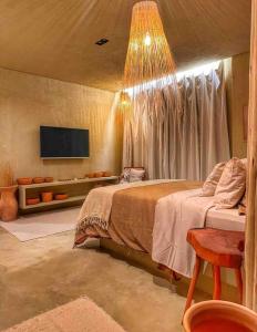 - une chambre avec un lit et une télévision murale dans l'établissement Villa Aconchego - Casas de Luxo, à São Miguel dos Milagres