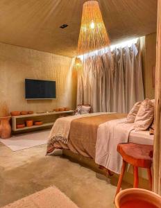 a bedroom with a bed and a tv on the wall at Villa Aconchego - Casas de Luxo in São Miguel dos Milagres