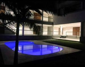 una casa con una palmera y una piscina azul en Duplex premium, excelente ubicacion II en Yerba Buena