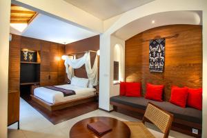a bedroom with a bed and a table in a room at Abia Villa & Suite Legian in Legian +95 photos