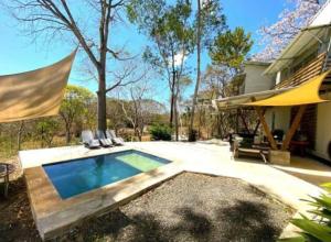 un patio trasero con piscina y una casa en Container home 25 min Jaco y Herradura en Tarcoles