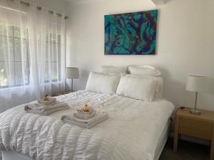 Una cama blanca con dos toallas encima. en Rosewhite House en Myrtleford