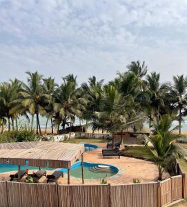 a resort with a pool and palm trees on the beach at Afiki in Ankwanda