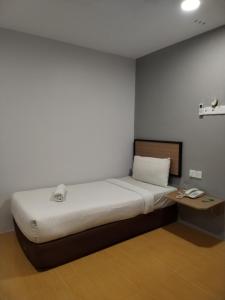 Habitación pequeña con cama y escritorio. en Maple Boutique Hotel Kota Bharu, en Kota Bharu
