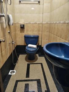 a bathroom with a blue toilet and a sink at Maple Boutique Hotel Kota Bharu in Kota Bharu