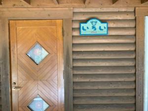 una porta di legno con un cartello sopra di Mori no Kuni - Vacation STAY 03869v a Ōma Altre 15 foto