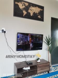 Afeny Homestay في تاواو: غرفة معيشة مع تلفزيون وخريطة على الحائط