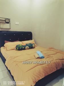 a bed with two pillows on top of it at Afeny Homestay in Tawau