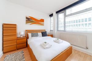a bedroom with a bed with two towels on it at Shiny 1BR Flat in Fitzrovia, 2 min to Tube in London