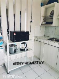 eine Küche mit einer Mikrowelle und einer schwarzen Mikrowelle in der Unterkunft Afeny Homestay in Tawau