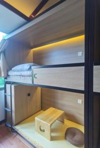 Pokój z 2 łóżkami piętrowymi i drewnianym stołem w obiekcie 不负韶华青年旅馆 Youth Hostel w mieście Suzhou