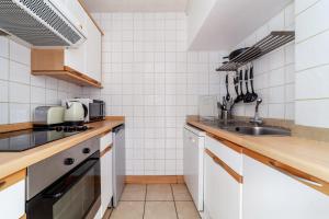 a kitchen with white appliances and a sink at Shiny 1BR Flat in Fitzrovia, 2 min to Tube in London