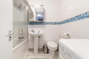 Shiny 1BR Flat in Fitzrovia, 2 min to Tube في لندن: حمام أبيض مع حوض ومرحاض