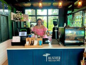 a woman standing behind a counter in a hair salon at Huather villa & cafe หัวเท่อวิลล่า in Ban Hin Sam Kon