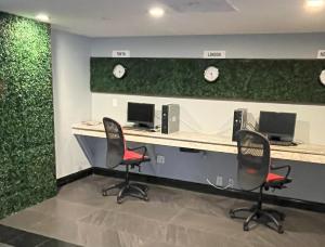 an office with two desks and two chairs and clocks at Grand Hotel Orlando at Universal Blvd in Orlando