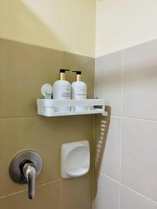 a bathroom with three bottles of soap and a sink at 2-Bedroom Condo Unit with Balcony at Centrio Tower beside Ayala Centrio Mall Downtown CDO in Cagayan de Oro