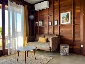 un soggiorno con divano e tavolo di Ti Kaz C2C - Une maison Balinaise a Saint-Pierre