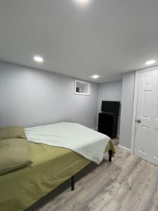 ein Schlafzimmer mit einem Bett und einer weißen Wand in der Unterkunft SUITE DREAM SHERMAN Room 23 in Passaic