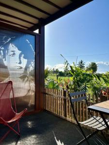 a screened in porch with a table and a chair at Ti Kaz C2C - Une maison Balinaise in Saint-Pierre