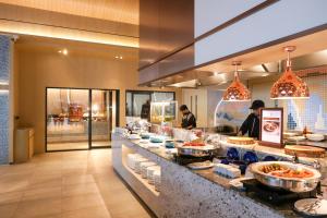 a buffet line in a restaurant with people preparing food at KC Grande Resort Koh Chang in Ko Chang +37 photos