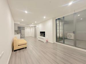 uma sala de estar com uma cadeira amarela e um sofá em Burwood Cozy Apartment Free Parking em Sydney