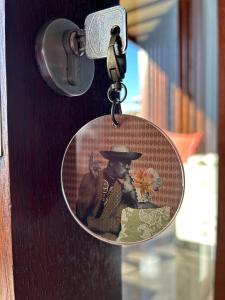 Eine Schlüsselkette mit einem Bild eines Mannes, der einen Hut trägt. in der Unterkunft Ti Kaz C2C - Une maison Balinaise in Saint-Pierre