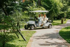 a group of three people riding a golf cart at Angkor Grace Residence & Wellness Resort in Siem Reap
