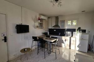 a kitchen with a table and chairs and a refrigerator at Beautiful T2 - close to the sea in La Seyne-sur-Mer