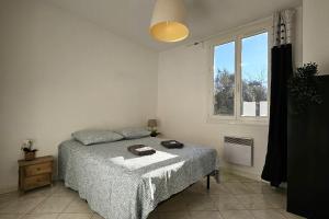 a bedroom with a bed and a window at Beautiful T2 - close to the sea in La Seyne-sur-Mer