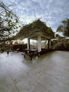 a pavilion with a picnic table and benches on a patio at Villa A & A Hikkaduwa in Hikkaduwa