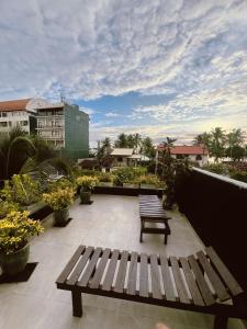 a wooden bench sitting on a balcony with plants at Villa A & A Hikkaduwa in Hikkaduwa