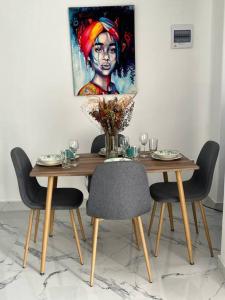 einen Esstisch mit Stühlen und ein Gemälde an der Wand in der Unterkunft Apartamento Lupe in Santa Marta
