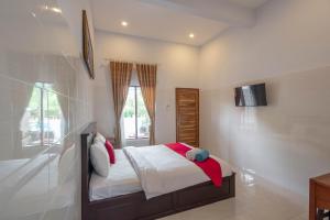 una camera da letto con un letto e una TV a parete di RedDoorz Plus @ Singaraja a Singaraja