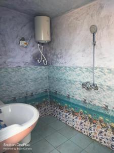 La salle de bains est pourvue d'une baignoire et d'un lavabo. dans l'établissement Solitude Homestay, Agoda, à Uttarkāshi