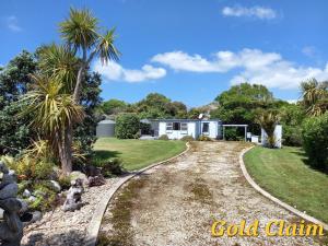 a driveway leading to a white house with palm trees at Charleston Goldfields Accommodation in Charleston