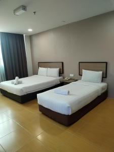 two beds in a hotel room with two beds sidx sidx sidx at Maple Boutique Hotel Kota Bharu in Kota Bharu