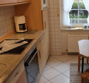 uma cozinha com fogão forno superior ao lado de uma janela em Ferienhaus Inselblick em Dornumersiel