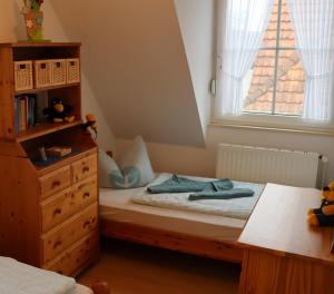 um quarto com uma cama, uma cómoda e uma janela em Ferienhaus Inselblick em Dornumersiel