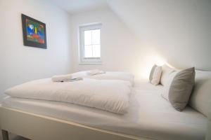 PuddeminにあるFerienhaus Wildrose in der Puddeminer Wiekの白いソファの上に置かれた白いベッド