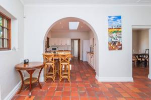 een boog in een keuken met een tafel en stoelen bij Spacious family Home in Constantia with Pool in Kaapstad
