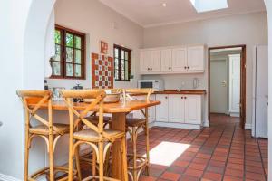 een keuken met een houten tafel en stoelen bij Spacious family Home in Constantia with Pool in Kaapstad