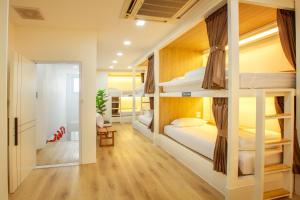 a dorm room with bunk beds and a hallway at Lafami Hostel in Ban Nongdouang