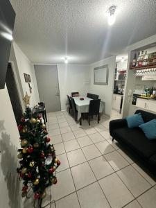 ein Weihnachtsbaum mitten im Wohnzimmer in der Unterkunft A pasos del aeropuerto in La Serena