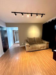 un salon avec un canapé et un parquet dans l'établissement Apartamento no Centro Balneário Camboriú, à Balneário Camboriú