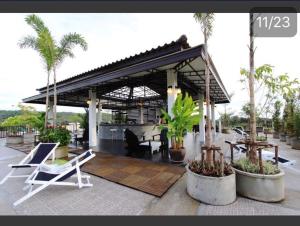 un pabellón con mesa, sillas y palmeras en KRABI MORE HOTEL, en Klong Muang Beach