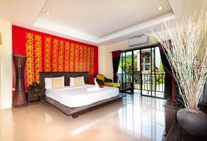 1 dormitorio con cama y pared roja en KRABI MORE HOTEL, en Klong Muang Beach