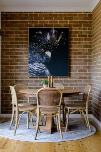 a dining room with a table and chairs and a brick wall at Bluestone Cottage - Character & Class in Orange