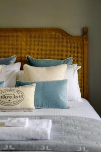 Una cama con almohadas azules y blancas. en Bluestone Cottage - Character & Class en Orange