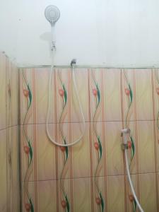 y baño con ducha con cabezal de ducha. en Saturnus Homestay kaper, en Labuan Bajo