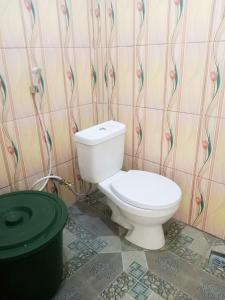 baño con aseo blanco en una habitación en Saturnus Homestay kaper, en Labuan Bajo
